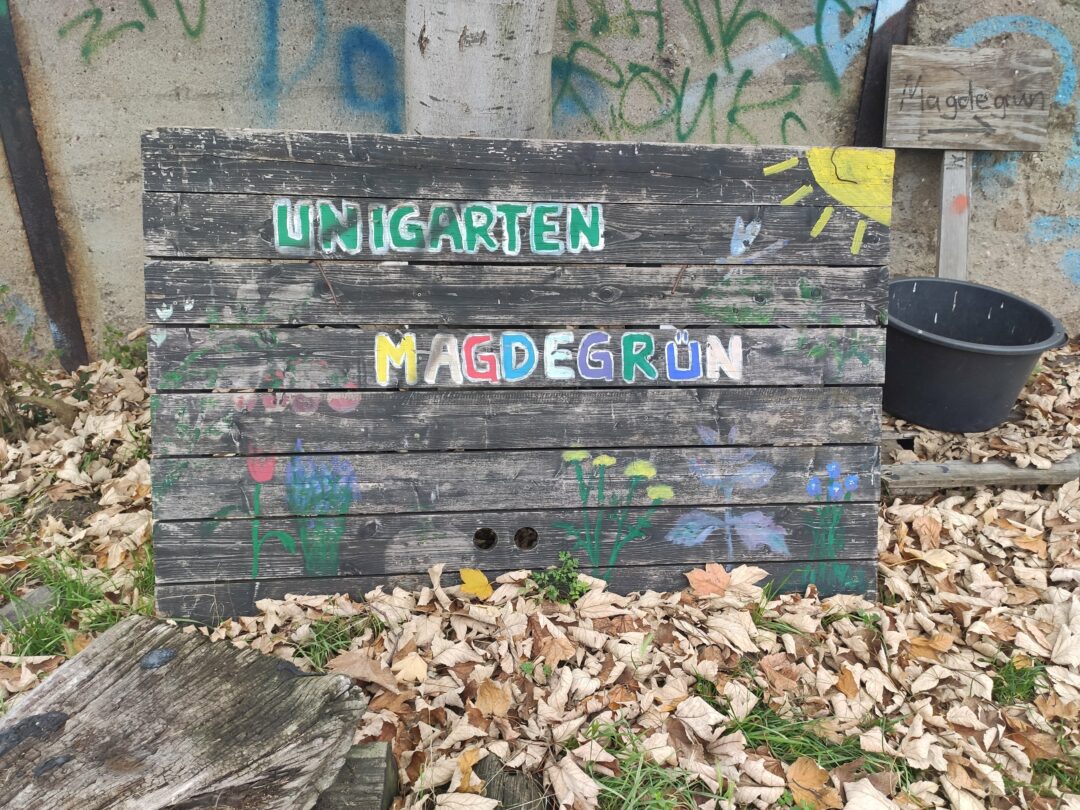 Schild mit bunter Aufschrift "Unigarten Magdegrün"