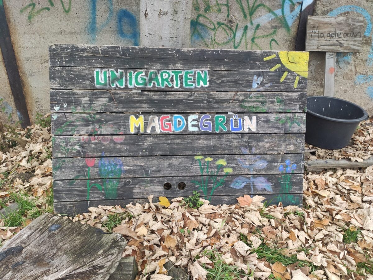 Schild mit bunter Aufschrift "Unigarten Magdegrün"